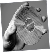 Kézben tartott CD lemez adóformanyomtatvánnyal Egy kéz tart egy CD lemezt, amelyen adóformanyomtatvány szövege látható.