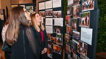 Kiállítás fotókkal és információs táblákkal Emberek egy kiállításon, ahol fotókat és információs táblákat néznek meg, csoportkép 2018-2023 felirattal.