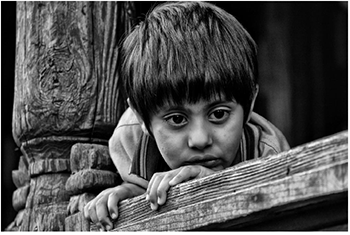 Kisgyermek támaszkodik egy fa korláton Kisgyermek támaszkodik egy fa korláton, fekete-fehér kép