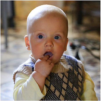 Kisgyermek mintás pulóverben Kisgyermek mintás pulóverben, háttérben homályos környezet