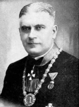 Kitüntetéseket viselő személy portréja Egy személy kitüntetéseket visel a nyakában és a mellkasán, díszruhába öltözve.