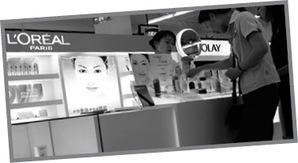 Kozmetikai üzlet L'Oreal és Olay termékekkel Nő vásárol L'Oreal és Olay termékeket egy kozmetikai üzletben.