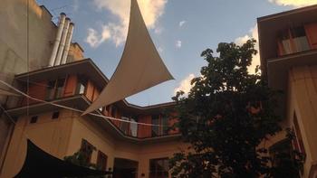 Modern belső udvar napvitorlákkal Modern belső udvar napvitorlákkal, növényekkel és kék ég háttérrel.