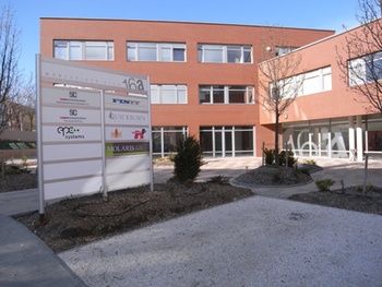 Modern irodaház bejárata Montevideo utcában, cégtáblával és logókkal.