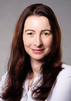 Nő hosszú barna hajjal, fehér blúzt visel, divatos megjelenés