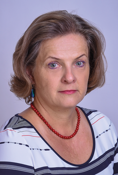 Nő piros nyaklánccal és kék fülbevalóval Nő rövid, hullámos barna hajjal, piros gyöngy nyaklánccal és kék fülbevalóval, csíkos ruhában