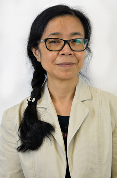 Nő világos zakóban, fonott fekete hajjal Nő világos zakóban, hosszú fekete haját fonatba kötve