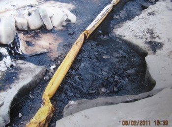 Olajszennyezés és olajfogó gát 2011 februárjában Olajszennyezés egy területen, ahol egy sárga olajfogó gát próbálja megakadályozni a szennyezés terjedését. Dátum: 08/02/2011 15:39.