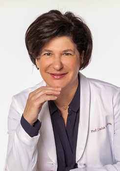 Prof. Csutak Adrienne fehér köpenyben, amelyen a neve szerepel.