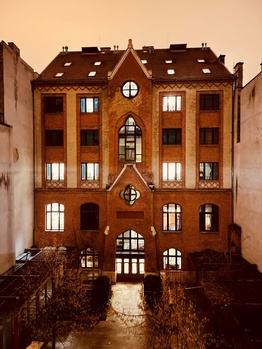 Régi téglából épült gótikus stílusú épület Régi, téglából épült, többemeletes épület gótikus stílusú homlokzattal, világító ablakokkal és udvarral.