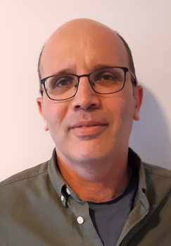 Egy személy zöld inget visel, a felsőtest látható.