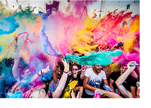 Színes porral teli fesztivál Tömeg színes porokat dobál a levegőbe egy fesztiválon, élénk színek kavalkádja.