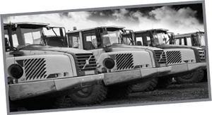 Teherautók parkolva egymás mellett Szürkeárnyalatos kép több teherautóról, amelyek egymás mellett parkolnak.