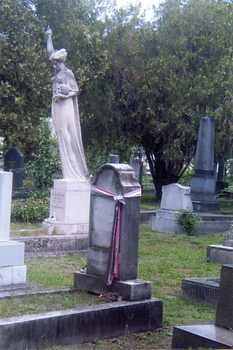 Temető sírkövekkel és szoborral Temető sírkövekkel, szoborral és zöld növényzettel, feliratokkal.