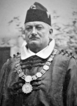 Történelmi személy díszes ruhában jelképes lánccal Történelmi személy díszes ruhában, nyakában jelképes lánccal és medálokkal.