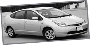 Toyota Prius hibrid autó Szürke Toyota Prius hibrid autó parkol egy üres területen.